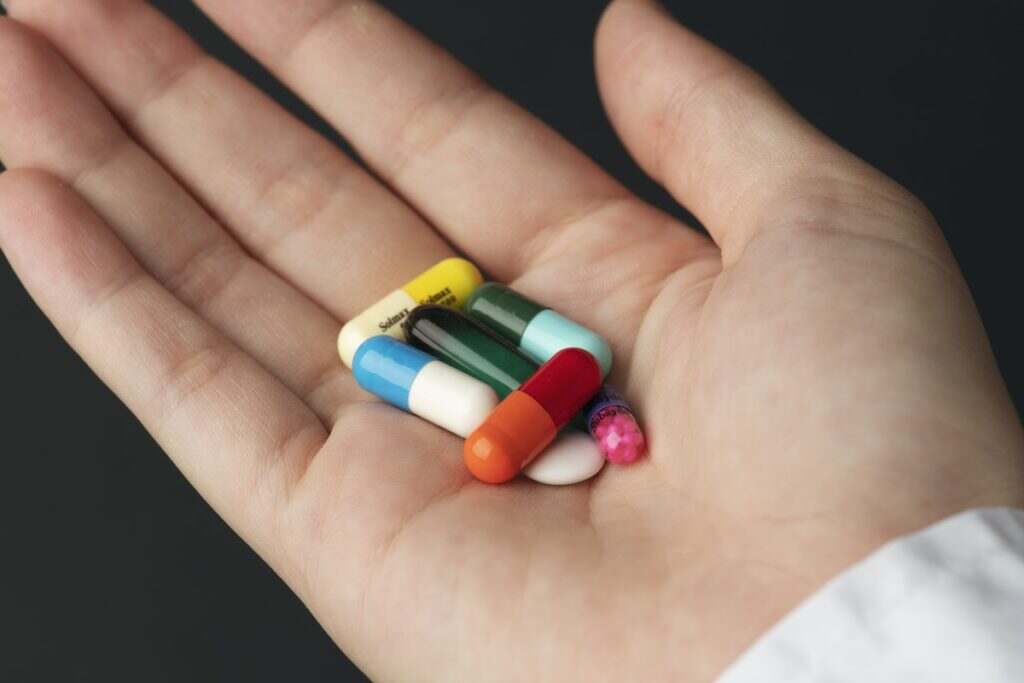 close up of a hand holding pills