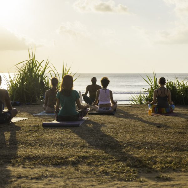 Balangan, Bali, Indonesia - August 9, 2014: Bali is a spiritual place where people from all the world can practise spiritual arts and exercises. In the beach of Balangan every morning and every afternoon before the sunset offer a wonderful experience for yoga practices.
